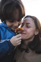 un enfant donne une fleur à sa mère photo