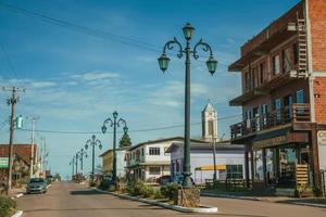 cambara do sul, brésil - 19 juillet 2019. poteaux d'éclairage flamboyants et maisons avec magasin sur l'avenue getulio vargas à cambara do sul. une petite ville rurale avec des attractions touristiques naturelles étonnantes. photo