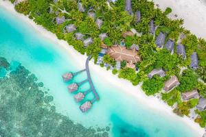 paysages paradisiaques des maldives. vue de dessus paysage aérien tropical, paysage marin avec longue jetée, villas sur l'eau, magnifique plage de la mer et du lagon, nature tropicale. bannière de destination touristique exotique, vacances d'été