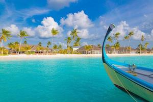 conception inspirante de la plage des maldives. dhoni de bateau traditionnel des maldives et mer bleue parfaite avec lagon. vue paradisiaque de l'hôtel de villégiature tropicale de luxe. côte idyllique, rivage de sable blanc, palmiers photo