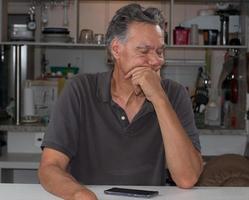 homme mûr à la maison s'ennuie en pensant à ce qu'il faut faire photo