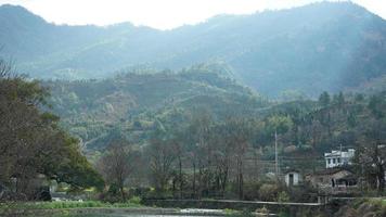 la belle et ancienne vue sur le village chinois traditionnel avec les montagnes qui l'entourent situé dans la campagne du sud de la chine photo