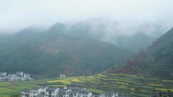 la belle vue sur les montagnes avec la forêt verte et les nuages s'élevant d'eux le jour de pluie dans la campagne du sud de la chine photo