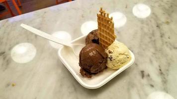 motif de dessert glacé à saveur de crème glacée dans une tasse blanche tenant la main sur la table. photo