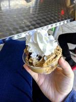 motif de dessert glacé à saveur de crème glacée dans une tasse blanche tenant la main sur la table. photo