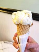 motif de dessert glacé à saveur de crème glacée dans une tasse blanche tenant la main sur la table. photo