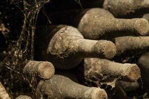 beaucoup de vieilles bouteilles de vin sur le web dans le gros plan de la cave à vin photo