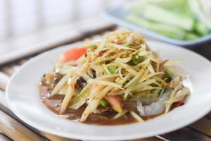 salade de papaye aux crevettes dans un plat blanc. cuisine thaïlandaise délicieuse et populaire