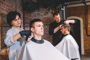 les coiffeurs coupent leurs clients dans un salon de coiffure. concept de publicité et de salon de coiffure photo