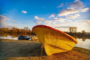 vieux bateau jaune au sol au bord du lac photo