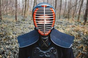 Portrait d'homme combattant de kendo sur fond de forêt photo