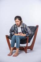 une femme assise sur une chaise avec des douleurs abdominales et appuyant sa main sur son ventre photo