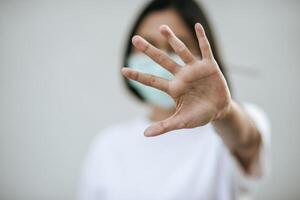 les femmes portent des masques et interdisent en levant les mains devant. photo