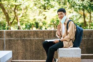 un homme assis et lisant un livre dans les escaliers. photo