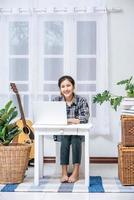 une femme assise joyeusement avec un ordinateur portable à la table photo