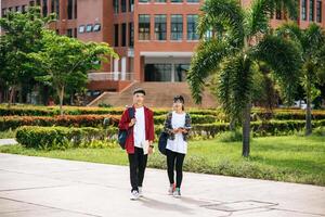 les étudiants masculins et féminins portent un visage froid et se tiennent devant l'université. photo