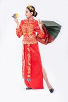 femme porter un costume cheongsam sourire pour utiliser une carte de crédit pour faire du shopping dans le nouvel an chinois photo