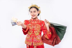 une femme porte un costume cheongsam obtient beaucoup de choses en utilisant une carte de crédit au nouvel an chinois photo