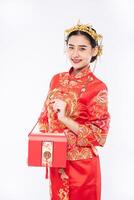 femme porter un costume cheongsam sourire pour obtenir de l'argent cadeau du patron dans le nouvel an chinois photo