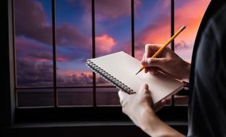 Close up of woman's hand writingis prenant des notes en se tenant debout photo