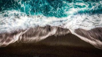 les vagues de la mer s'écrasent sur la côte sablonneuse prise d'en haut par un drone sur les plages italiennes