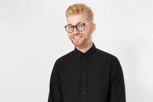 jeune homme aux cheveux roux souriant avec des lunettes souriant isolé sur fond blanc. photo