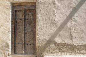 vieille porte en bois et mur exfoliant dans la ville historique, asie centrale photo