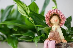 une statuette souvenir d'une jeune fille assise sur un fond de feuillage photo