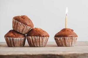 cupcakes au chocolat avec bougie sur table en bois photo