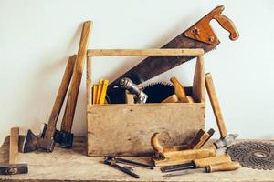 vieille boîte à outils en bois pleine d'outils. vieux outils de menuiserie. table de menuisier. boiseries photo