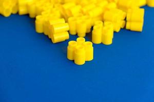 blocs de construction en plastique jaune sur fond bleu photo