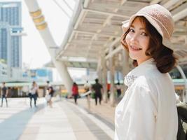 Jolie jeune femme asiatique souriante portrait en plein air dans la série de personnes réelles de la ville. mode de vie en plein air mode portrait de fille asiatique souriante heureuse. concept de portrait de bonheur en plein air d'été. photo