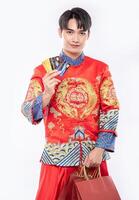 l'homme porte un costume cheongsam obtient beaucoup de choses en utilisant une carte de crédit au nouvel an chinois photo
