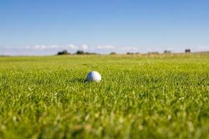balle de golf allongée sur un terrain de golf dans l'herbe par une journée ensoleillée concept de golf. place pour le texte photo