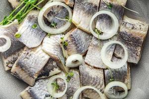 tranche de hareng morceaux de poisson avec oignon fruits de mer repas sain régime pescetarian photo