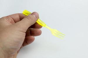 main tenant une fourchette en plastique. photo