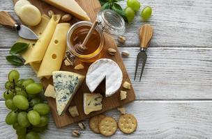 divers types de fromage sur un fond en bois blanc