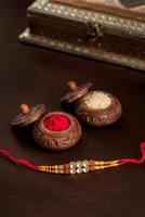 fond indien de raksha bandhan de festival avec un rakhi élégant, des grains de riz et du kumkum. un bracelet indien traditionnel qui est un symbole d'amour entre frères et sœurs. photo