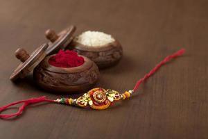 fond indien de raksha bandhan de festival avec un rakhi élégant, des grains de riz et du kumkum. un bracelet indien traditionnel qui est un symbole d'amour entre frères et sœurs. photo