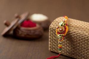 fond indien de raksha bandhan de festival avec un rakhi élégant, des grains de riz et du kumkum. un bracelet indien traditionnel qui est un symbole d'amour entre frères et sœurs. photo