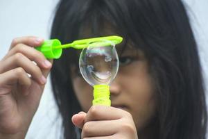 une fille tenant une machine à bulles et les soufflant. photo