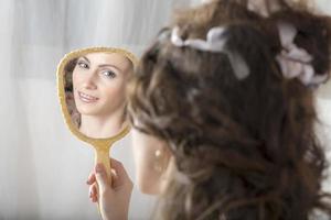 la fille se regarde dans le miroir. photo