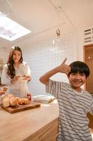 des moments heureux en famille lorsque les enfants aident maman à cuisiner dans la cuisine. photo