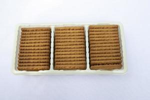 biscuits de blé de couleur brune dans le bac en plastique isolé sur fond photo