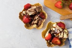 dessert à la crème glacée dans une gaufre aux fraises sur une table blanche d'en haut photo