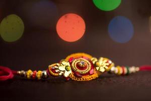 fond raksha bandhan avec un élégant rakhi. un bracelet indien traditionnel qui est un symbole d'amour entre frères et sœurs. photo