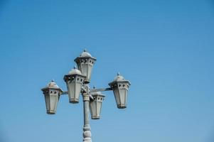 cinq lampadaires polygonaux sous un pilier dans le ciel bleu