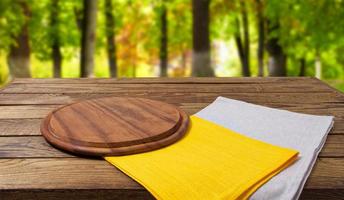 Bureau de coupe vide serviettes gris jaune sur table en bois sur fond de parc flou photo