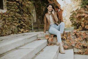 jeune femme avec un téléphone portable le jour de l'automne photo