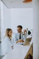 jeune couple d'affaires travaillant et discutant par ordinateur portable au bureau photo